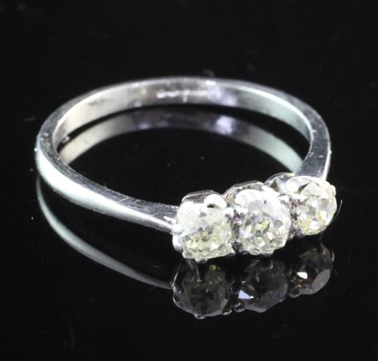 A platinum and three stone diamond ring, size Q.